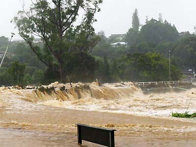 Water overflows the bridge and the road